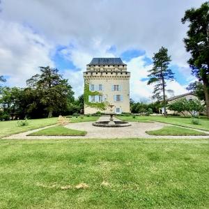 a building with a fountain in the middle of a field at Château Déhès Gazaupouy 1 chambre d'hôte et 1 Gite in Gazaupouy