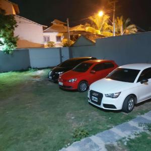 three cars parked in a yard at night at Posada Nihal in Búzios