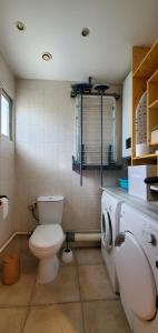 uma casa de banho com um WC e uma máquina de lavar roupa em bienvenue au Manava em La Grande-Motte