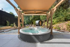 a hot tub in the middle of a patio at Aphrodites Group - Luxury Hot Tub Suites in Central Lake District! in Bowness-on-Windermere