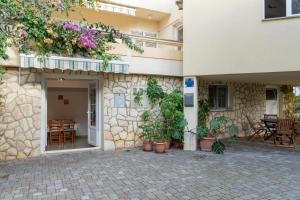 a building with potted plants on the side of it at Apartments Josipa in Mandre