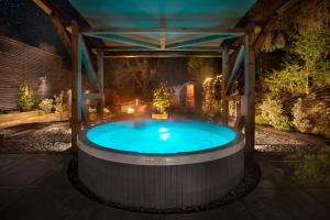 a hot tub in a garden at night at Aphrodites Group - Luxury Hot Tub Suites in Central Lake District! in Bowness-on-Windermere