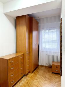 een slaapkamer met een houten kast en een raam bij Lina's Apartment in Skopje