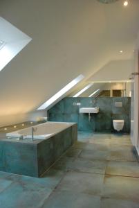 a large bathroom with a tub and a toilet at Sweet Clementine B & B in Hannover