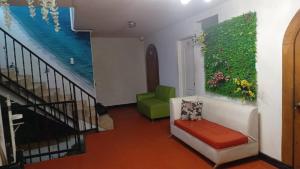 ein Wohnzimmer mit einem grünen Stuhl und einer Treppe in der Unterkunft Hotel Montañez in Cúcuta
