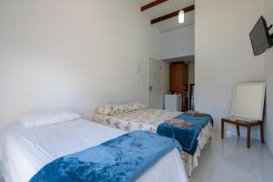 Habitación con 2 camas y espejo. en Suites Praia de Juquehy en Juquei