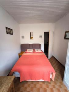 a bedroom with a large bed with a red blanket at Ma Maison de Campagne in Le Brusquet