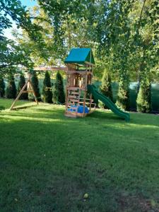 un pequeño parque infantil con un tobogán y un columpio en Domek pod Brzozami z jacuzzi ,grillem i tarasem en Przemyśl