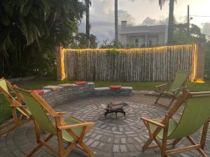 a patio with two lawn chairs and a fire pit at Pousada Pássaros Park in Itapoa