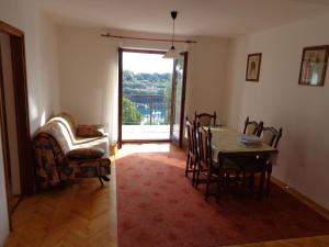 a dining room with a table and chairs and a window at Apartmani Marina in Labin