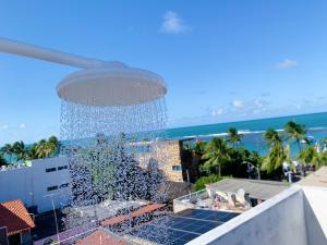 a water fountain on top of a building with the beach at Flats e Suítes Elcaline in Porto De Galinhas