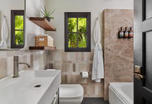 棕櫚泉的住宿－Lucille Palm Springs，浴室配有盥洗盆、卫生间和浴缸。