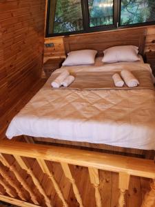 cottage vizitori في باتومي: سرير في كابينة خشب مع وسادتين