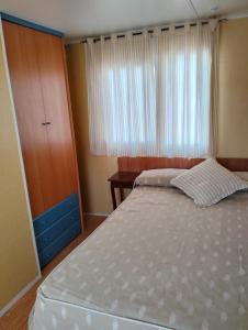a bedroom with a bed and a dresser and a window at CASITA AZUL MUÑICO , AVILA in Muñico