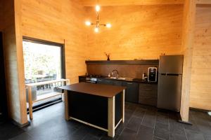 a kitchen with a refrigerator and a table in it at Pensiunea Hardic in Horodnic de Sus