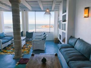 a living room with a couch and a view of the ocean at Riad Dar alma in Essaouira