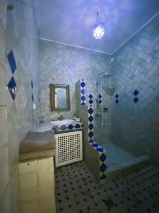 a blue and white bathroom with a tub and a sink at Riad Dar alma in Essaouira