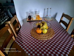 a table with a basket of fruit on a checkered table cloth at Zoe garden home in Spáta