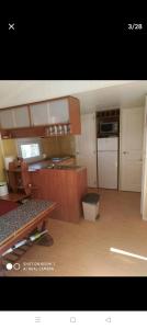 a kitchen with wooden cabinets and a counter top at CASITA AZUL MUÑICO , AVILA in Muñico