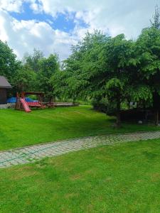 a park with a tree and a playground at Privát Majo in Liptovský Mikuláš
