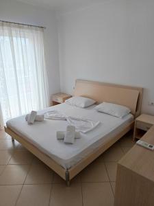 een slaapkamer met een bed met twee handdoeken erop bij Villa Kleo Ksamil in Ksamil