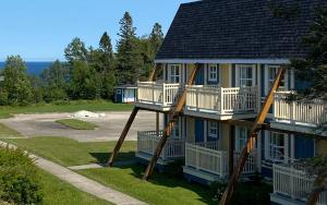 a house with two decks on the side of it at Hébergement Fort Prével in Saint-Georges-de-Malbaie