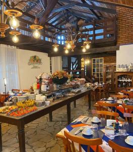 um restaurante com uma longa mesa com comida em Pouso das Gerais em Tiradentes