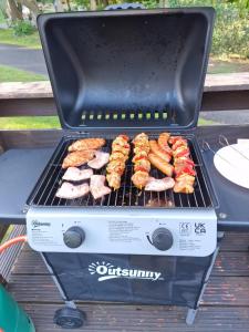 a grill with meat and other food on it at The Forest Cabin Holiday Home 15 in Ballantrae