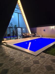 une grande piscine bleue dans une maison dans l'établissement Gabala Twin A Frame Villas, à Qabala