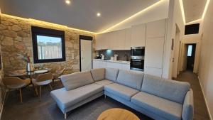 a living room with a blue couch and a kitchen at Exclusive new villa with private pool - 2BR in Nea Fokea