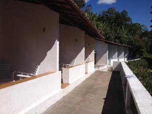 a row of white buildings with a sidewalk at Estancia Vale das Flores in Pacoti