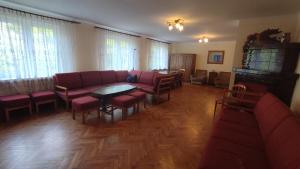 a living room with a couch and a table and chairs at Leśny Zajazd in Susiec