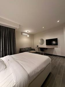 a bedroom with a bed and a couch and a television at The Ivory Hotel in Nairobi