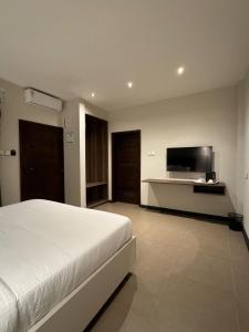 a bedroom with a bed and a flat screen tv at The Ivory Hotel in Nairobi