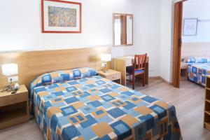 a hotel room with a bed and a table and a desk at Nautilus Hotel in Roses +38 photos