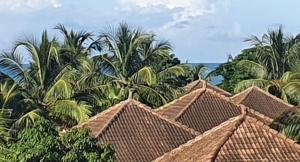a painting of a resort with palm trees and roofs at PENTHOUSE eagle saly in Sali Nianiaral