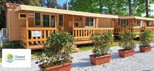 una cabaña de madera con macetas delante de ella en Mobile home Viareggio - including airco- Camping Paradiso - G008, en Viareggio