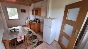 a small kitchen with a table and a refrigerator at Vila Zenyt in Piatra Fantanele
