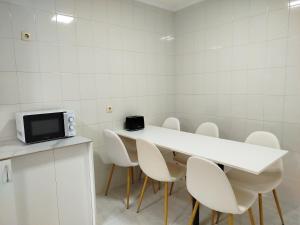 a room with a white table and white chairs at MARSÁN in Arzúa