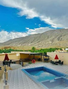a resort with a swimming pool and mountains in the background at WADI BANI KALED REST HOUSE in Dawwah