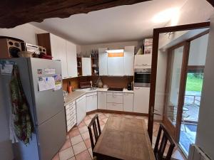 a kitchen with white appliances and a table and chairs at Maison de famille à la campagne classée 3 étoiles in Les Andelys +31 photos