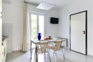 - une cuisine blanche avec une table et des chaises dans l'établissement Residence Diffuso Arcobaleno, à Gabicce Mare