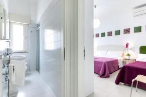 - une salle de bains blanche avec un lit et un lavabo dans l'établissement Residence Diffuso Arcobaleno, à Gabicce Mare