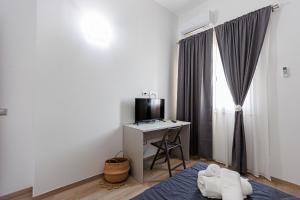una camera da letto con un letto e una scrivania con una televisione di La Rosa di Sharon a Portopalo Altre 36 foto