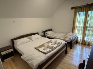 una camera da letto con due letti con asciugamani sopra di Vignjišta a Plužine