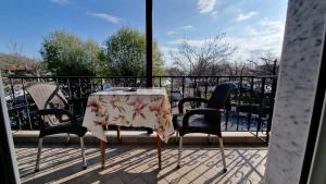 una mesa y sillas sentadas en un balcón en Villa Dimitris, en Paralia Panteleimonos