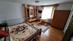 a bedroom with a bed and a table and a window at Vila Zenyt in Piatra Fantanele