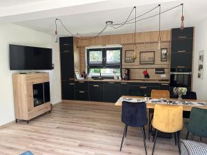 a kitchen with a table and chairs and a tv at Schmidtsches Quartier in Hain