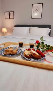 uma bandeja com dois pratos de comida numa cama em Hermes Modern Apartment em Alexandroúpolis