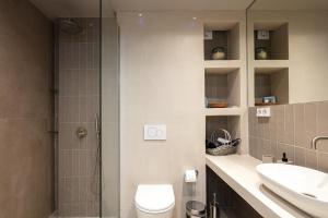 a bathroom with a shower and a toilet and a sink at Cozy garden apartment in Rethymno Town +4 photos